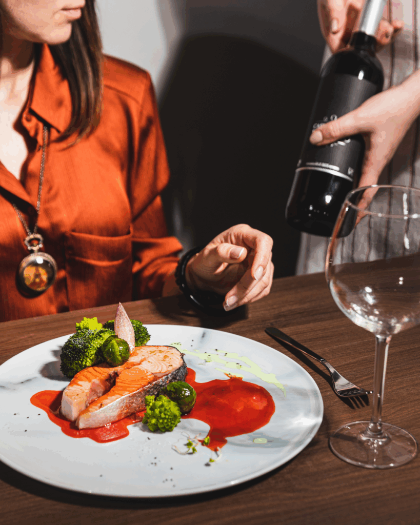 Frau bekommt Wein serviert in der Gastronomie